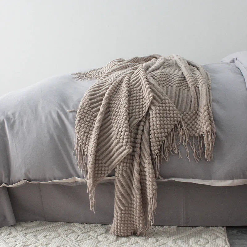 Light grey polyester throw blanket draped over a sofa, showing its size.