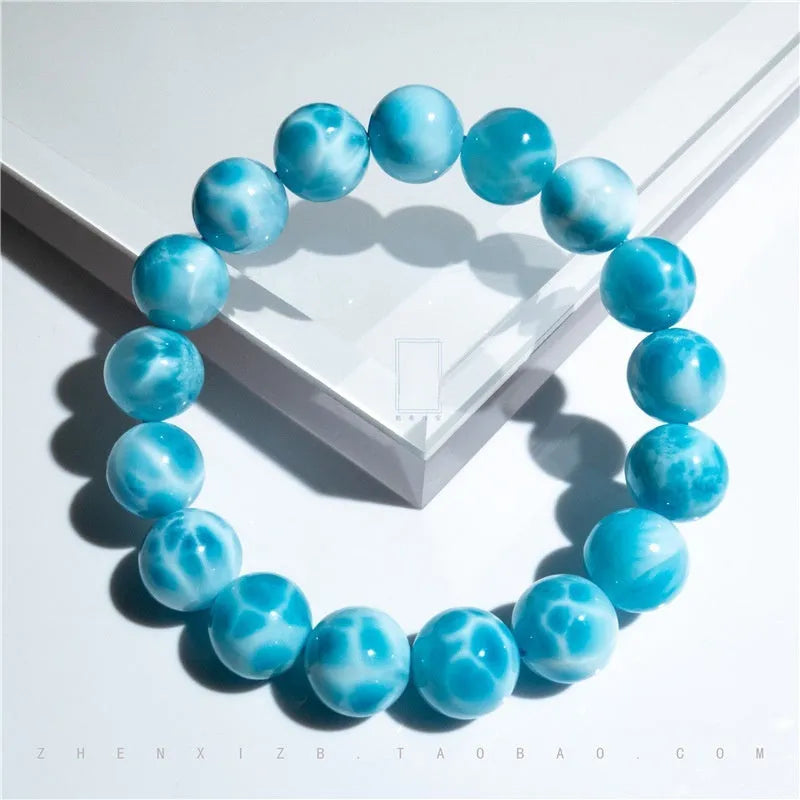 Blue Maillard-style bracelet with bodhi beads, natural crystal stone, and pearl accents on a wrist.