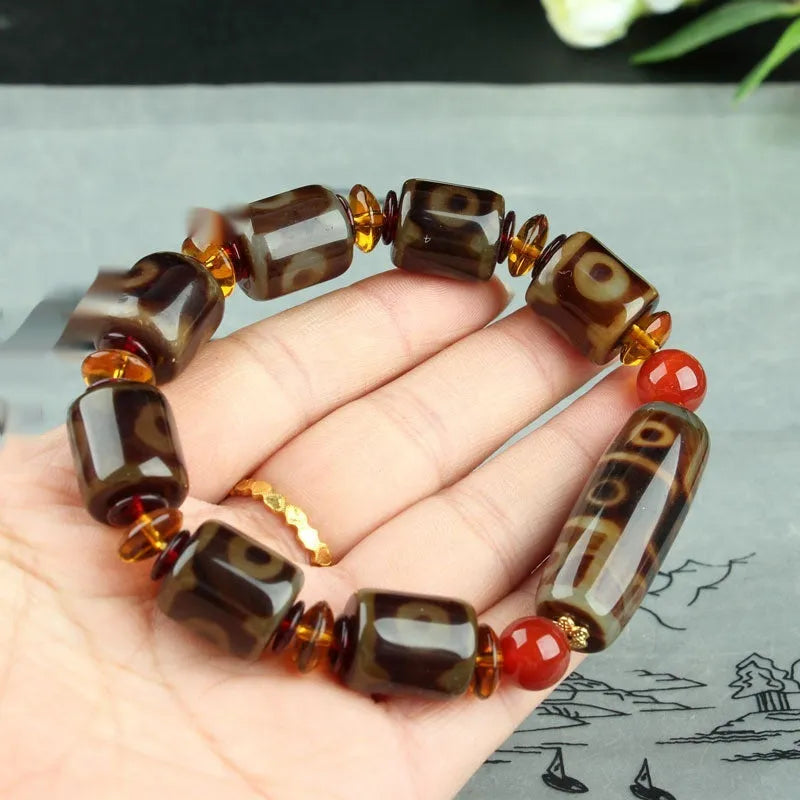 Distressed agate Tibet bead bracelet with three-eye motifs and multiple traditional bead styles on wrist