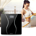 Black electronic digital bathroom scale with LCD display on a bathroom floor.