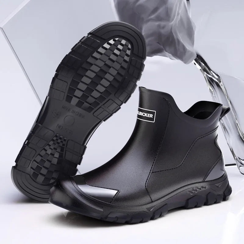Short black PVC wading boots with a round toe and flat heel on a white background.
