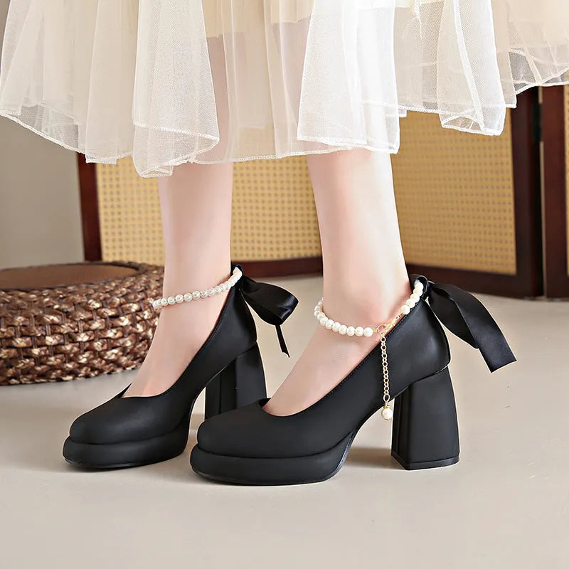 Women's beige Mary Jane shoes with chunky heel and ankle strap buckle on a wooden floor.