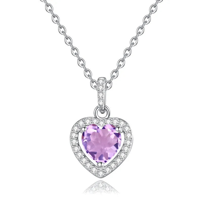 Heart-shaped sterling silver necklace with a round amethyst gemstone on a cross chain.
