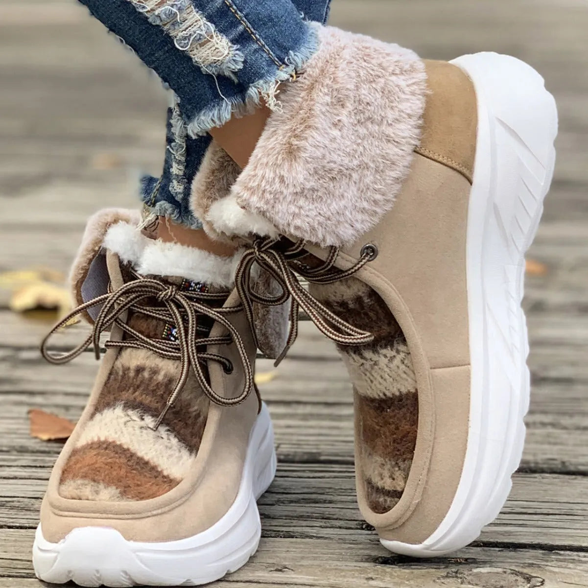 Women's beige lace-up snow boots with suede upper and fur lining on a white background.