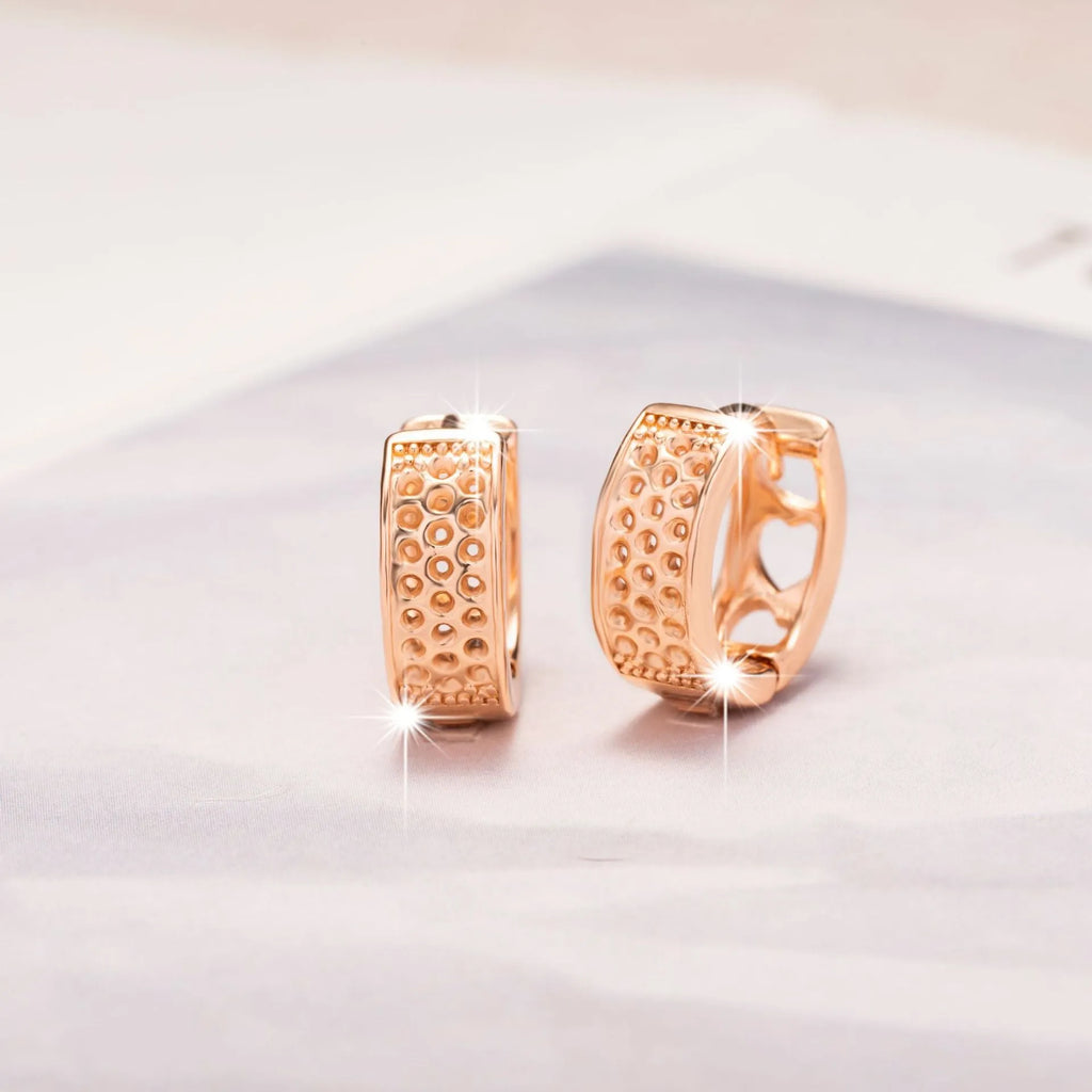 Rose gold circular women's earrings with a hollowed-out three-heart design.