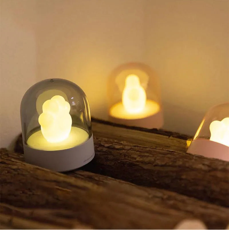 Grey and pink cat paw shaped USB rechargeable night light with music box on a desk