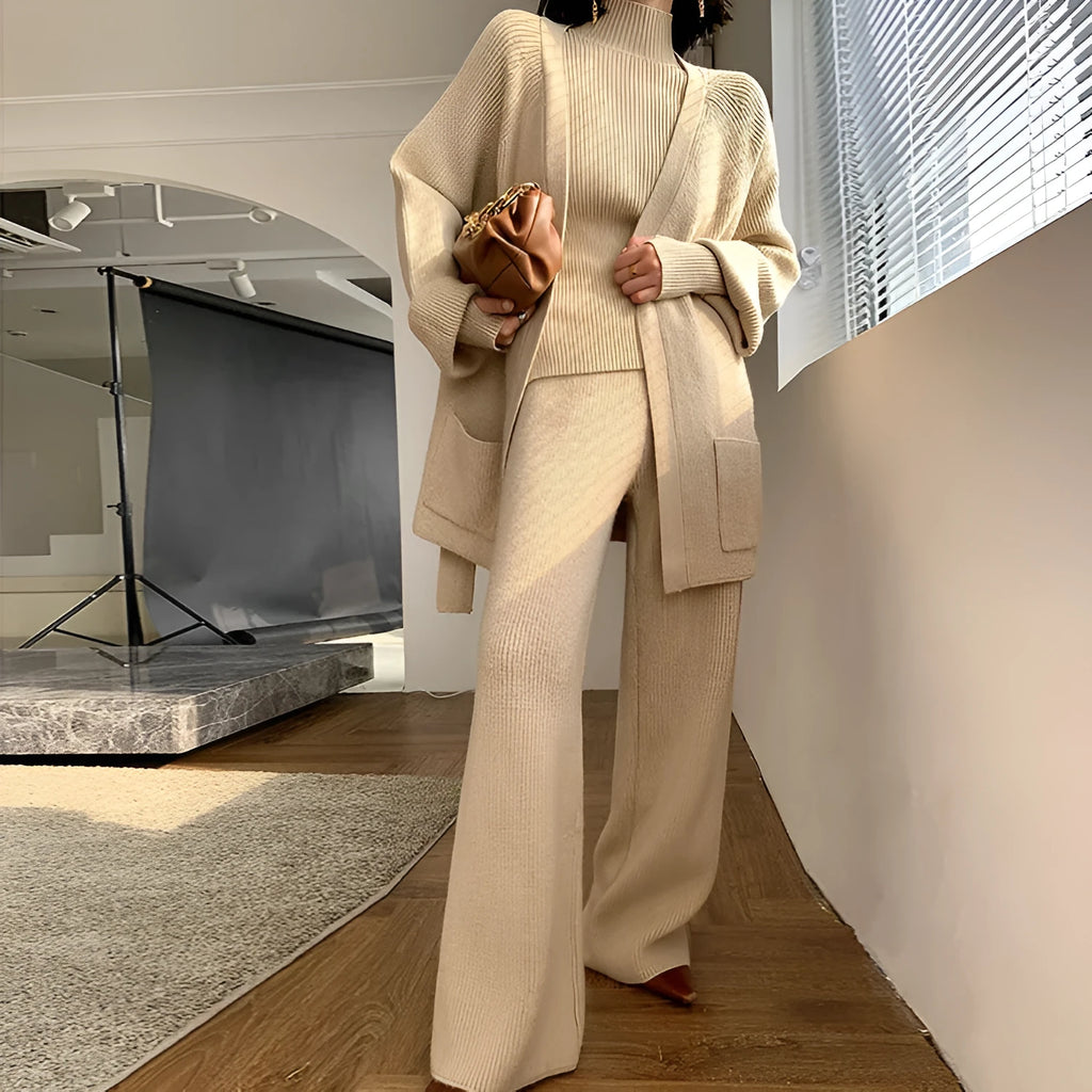 Women's knitted three-piece set showing sweater, wide-leg pants, and cardigan with leather stitching details