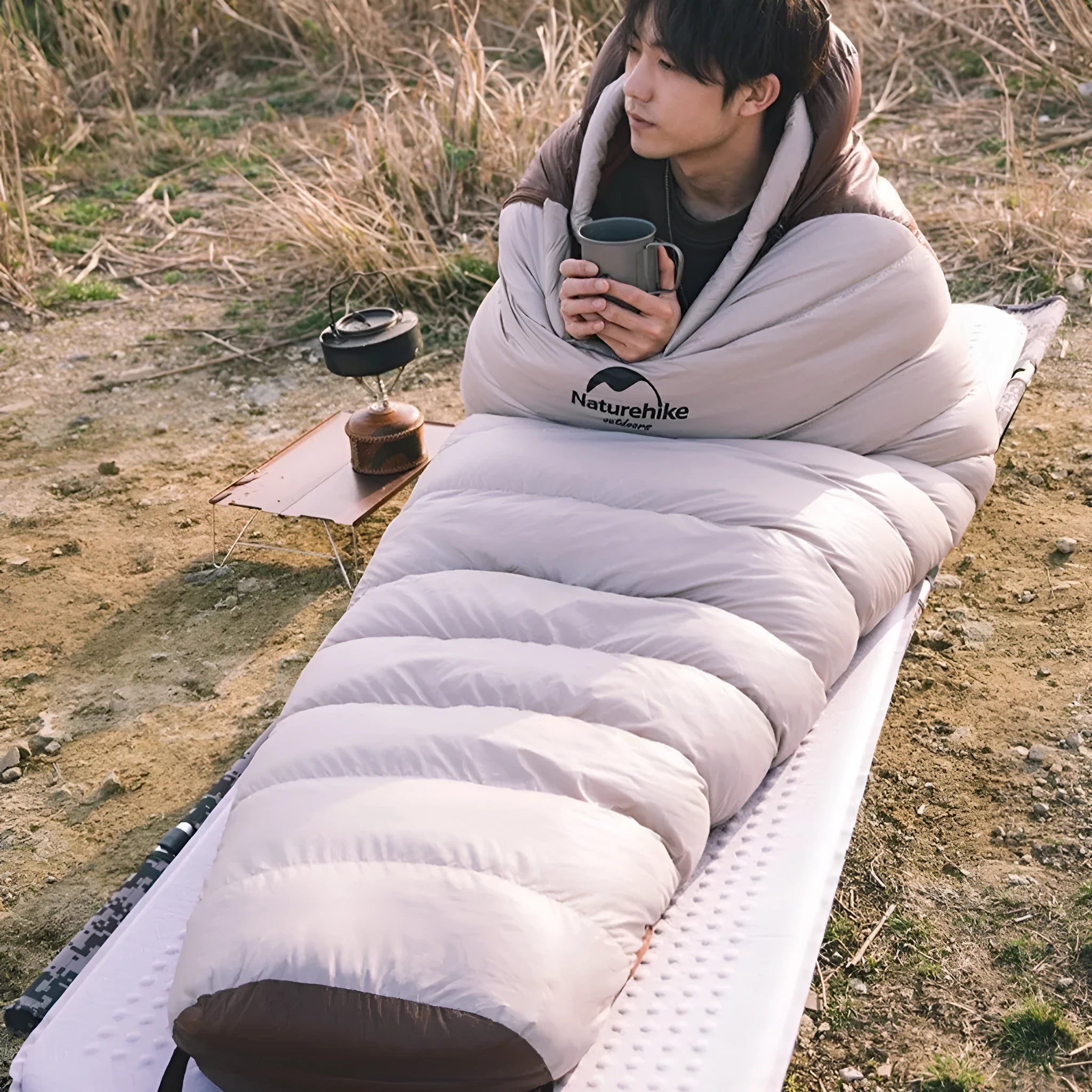 Goose down mummy-style sleeping bag with storage bag, shown in a colour option.