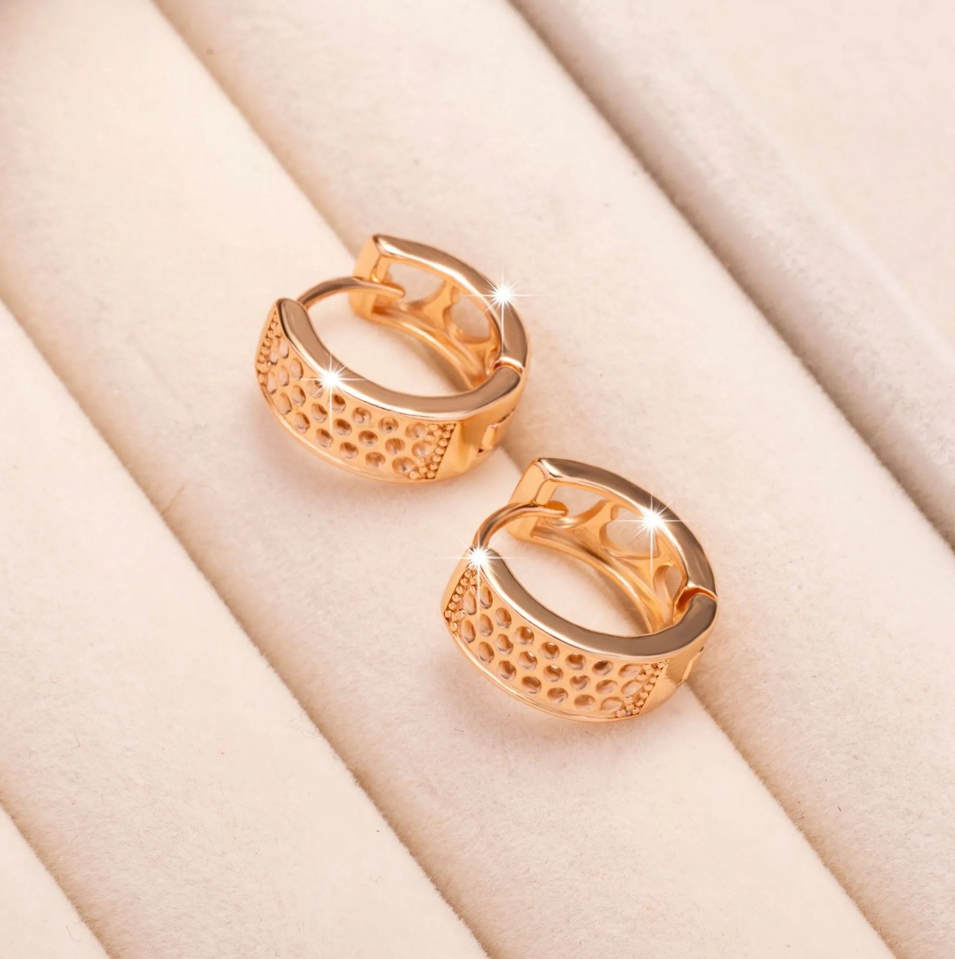 Rose gold circular women's earrings with a hollowed-out three-heart design.