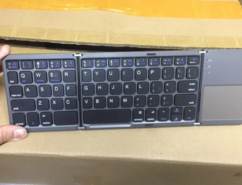 Ultra-thin tri-fold folding Bluetooth keyboard with touchpad shown in black and silvery white colours