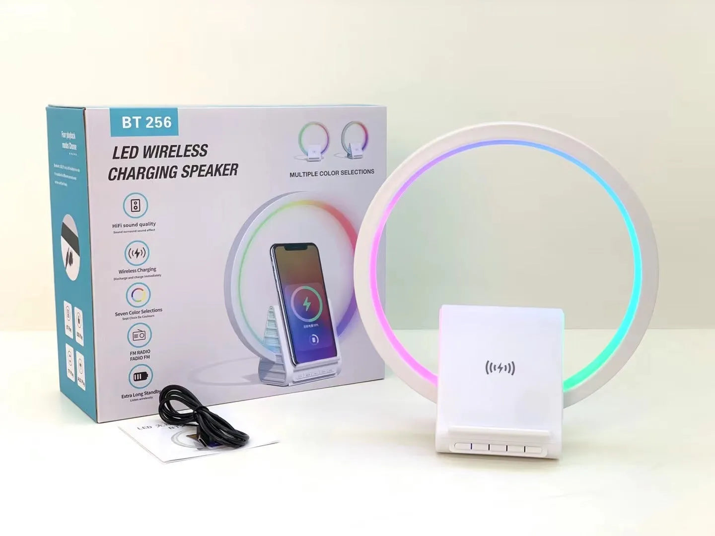White circular smart Bluetooth speaker with ambient lighting and wireless charging pad