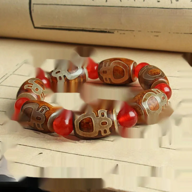 Distressed agate Tibet bead bracelet with three-eye motifs and multiple traditional bead styles on wrist