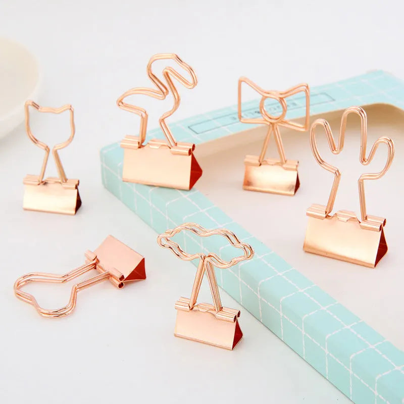 Gold-coloured metal office clip in decorative bow shape design
