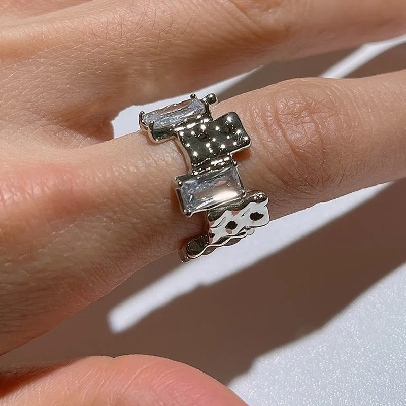 Geometric cross zircon ring with silver plating and open gemstone setting showing three-dimensional decoration