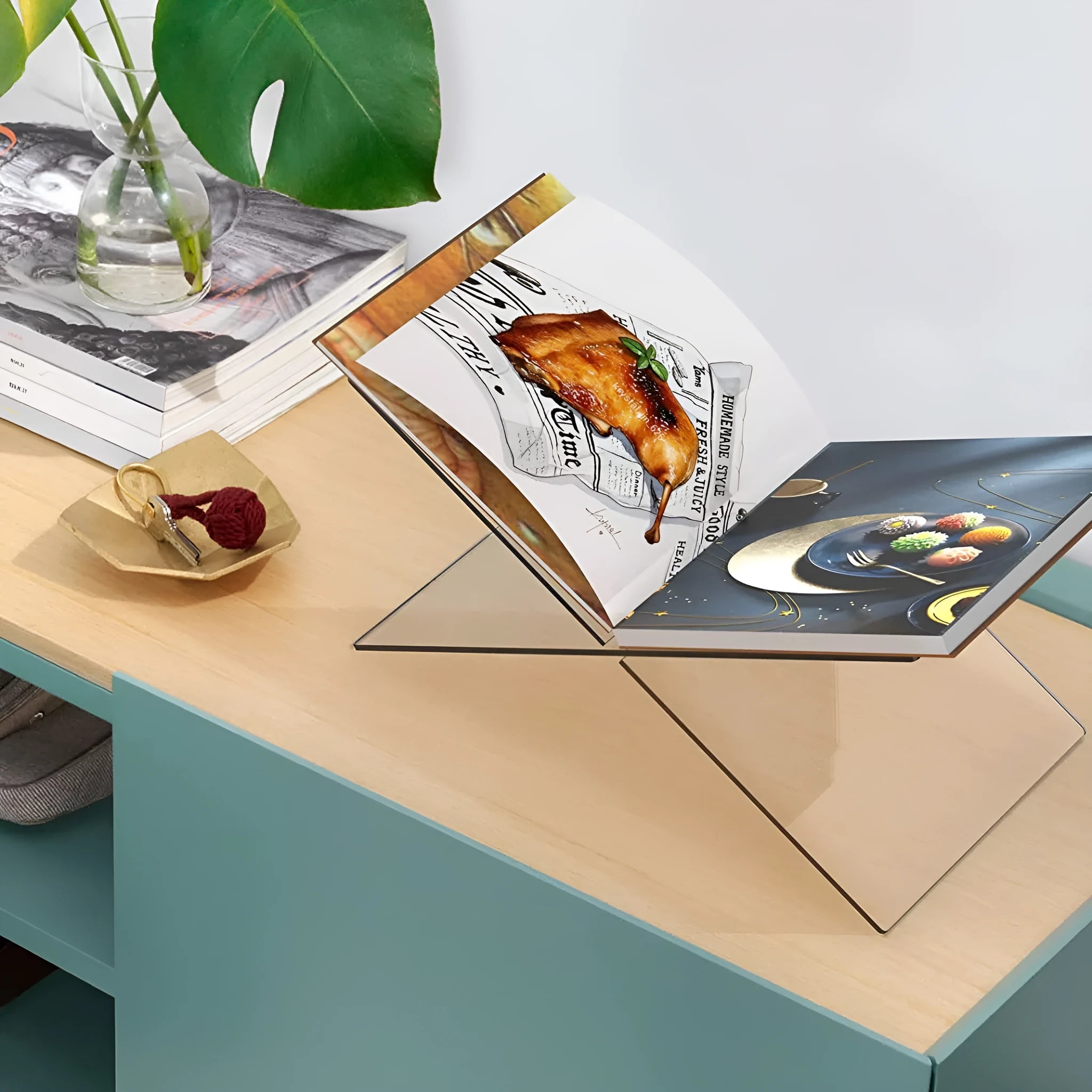 Clear acrylic X-shaped book reading rack holding books and magazines on a desktop