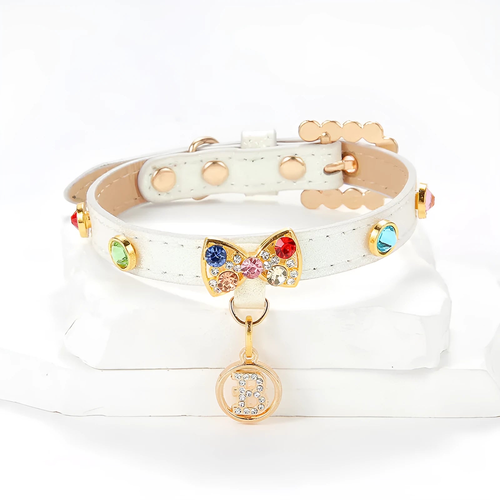 White PU leather cat collar with diamond alloy bow displayed on a surface, showing buckle and adjustable length