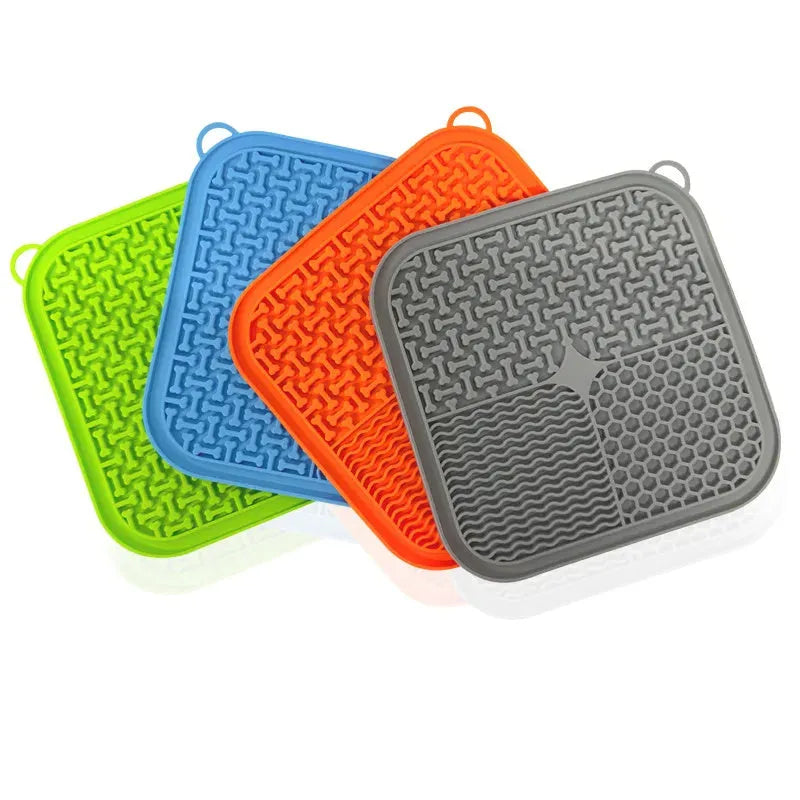Blue silicone dog licking mat with textured surface and suction cups on a kitchen floor.