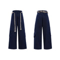 Men's dark blue straight-leg jeans showing heavy 3D stitching and tassel pocket decoration.