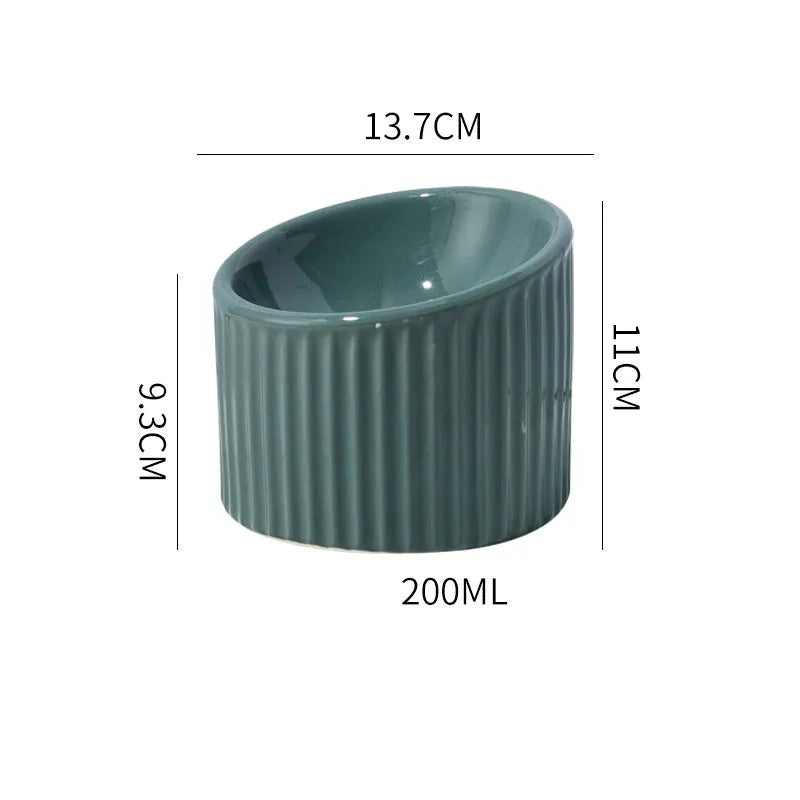 Ceramic elevated cat bowl in green or yellow with a tilted, round, whisker-friendly design.