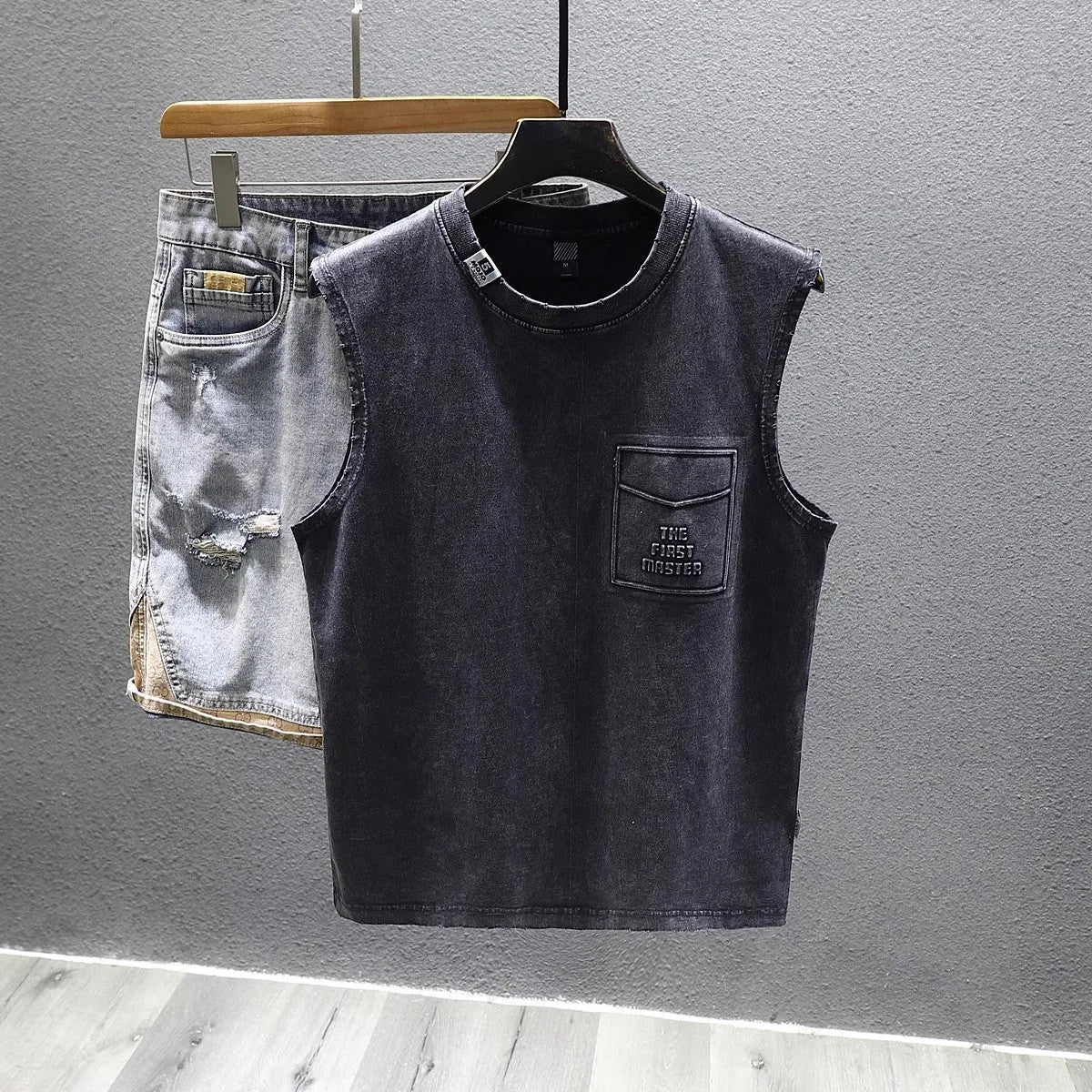 A man's solid colour loose-fit cotton sleeveless t-shirt with a straight hem.