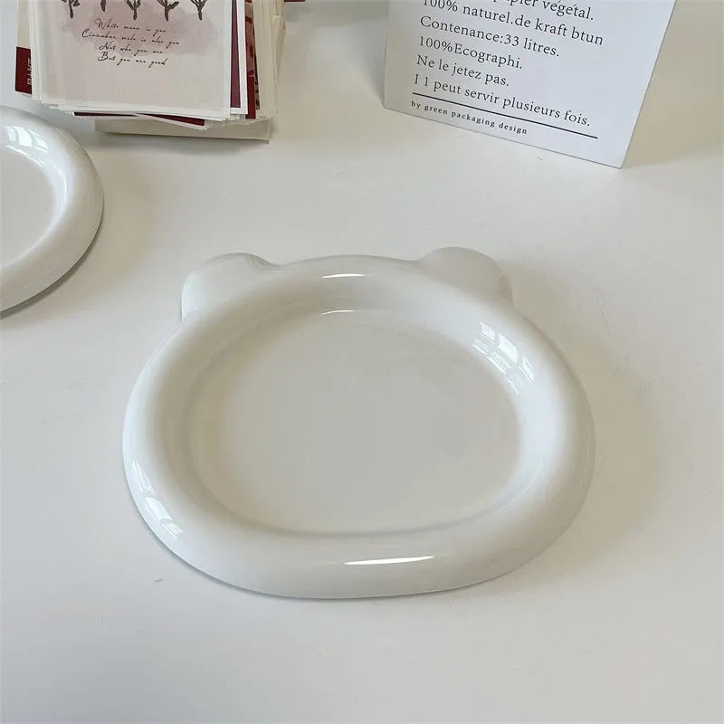 White ceramic plate with black hand-drawn doodle design, shown in bear and round patterns.