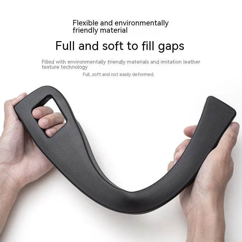 Black plastic car seat gap storage box with handle positioned between vehicle seats