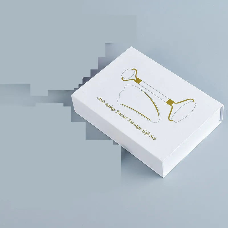 White jade dual-head facial roller and gua sha tool with a separate massage board on a plain background.