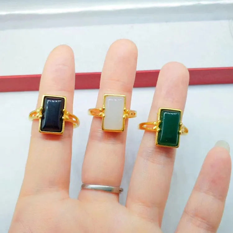 Adjustable gold-plated brass ring with a central gemstone inlay on a model's finger.