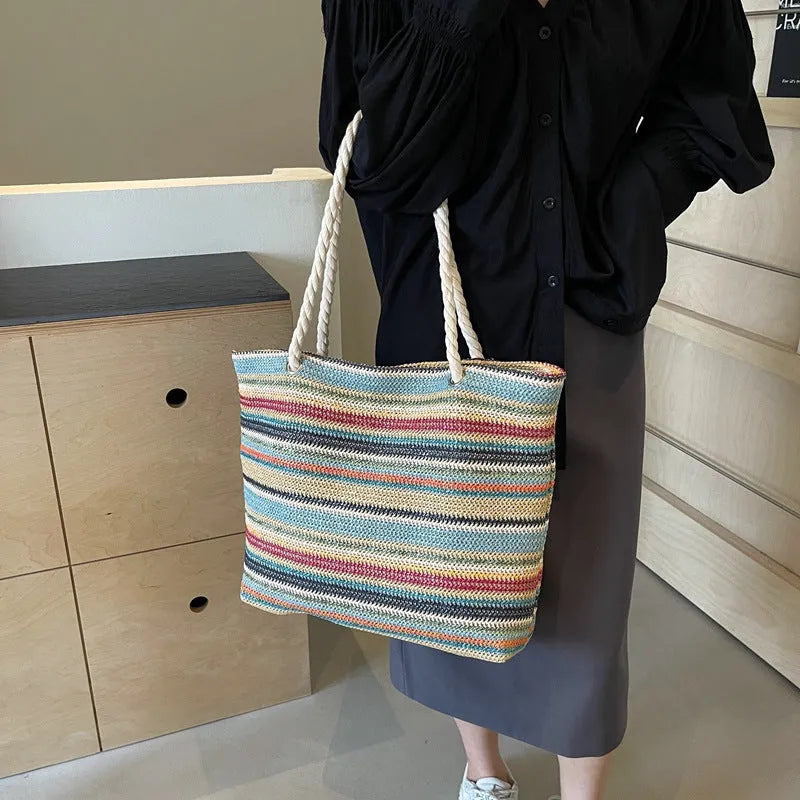 Blue straw woven nylon shoulder bag with large capacity and polyester lining.