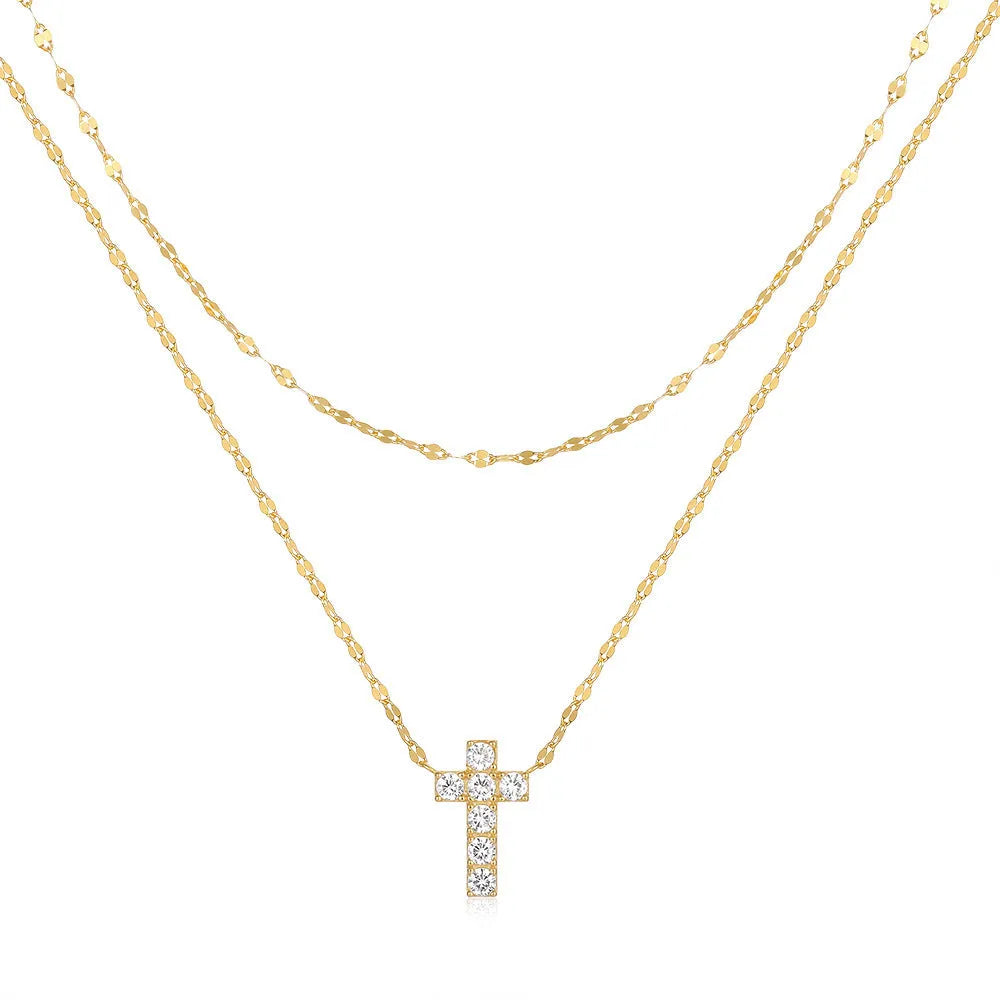 Close-up of a double-layer sterling silver cross pendant on a clavicle chain, available in gold and white gold finishes.