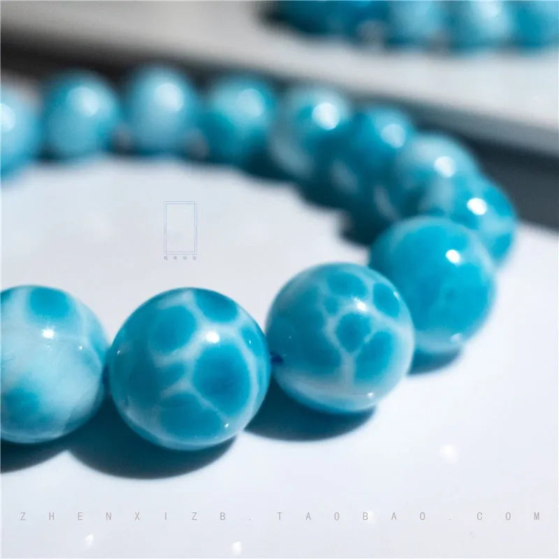 Blue Maillard-style bracelet with bodhi beads, natural crystal stone, and pearl accents on a wrist.