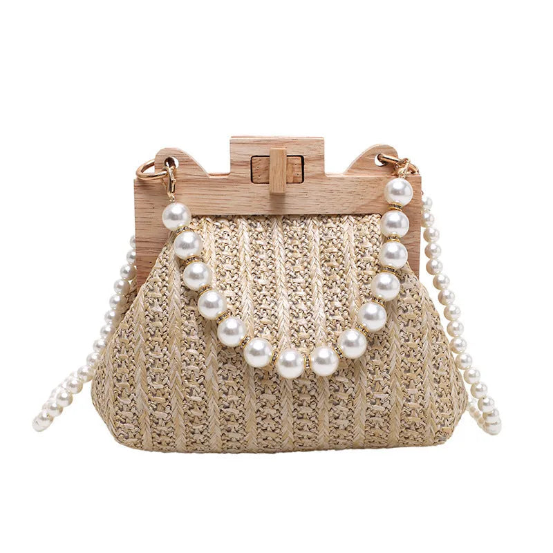 Women's woven straw shoulder bag with pearl chain strap in beige, showing its horizontal square shape.