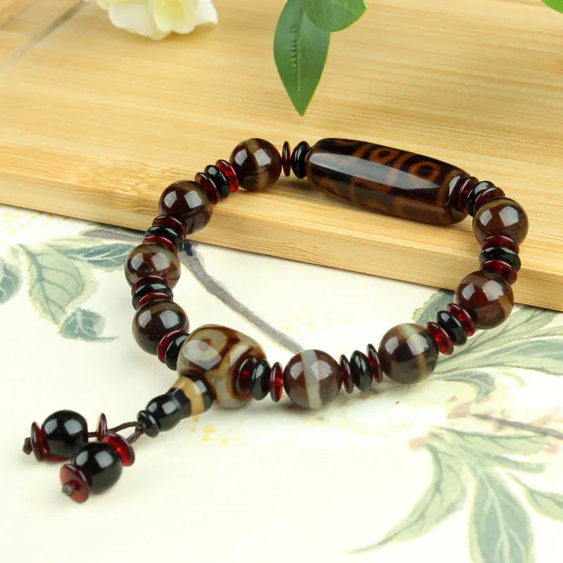 Distressed agate Tibet bead bracelet with three-eye motifs and multiple traditional bead styles on wrist