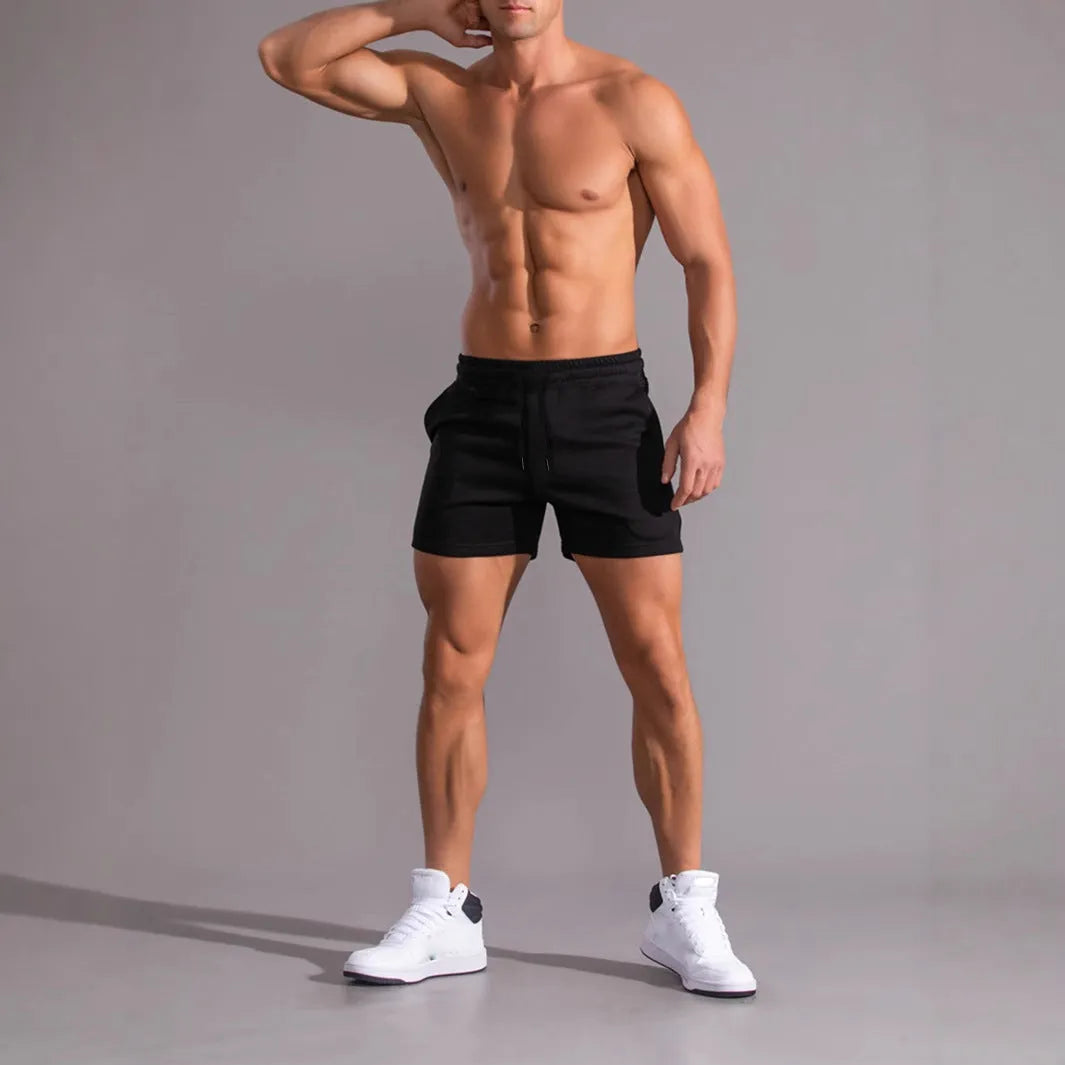 Men's black, khaki, and light brown drawstring casual shorts laid flat, showing loose fit and elasticated waistband.