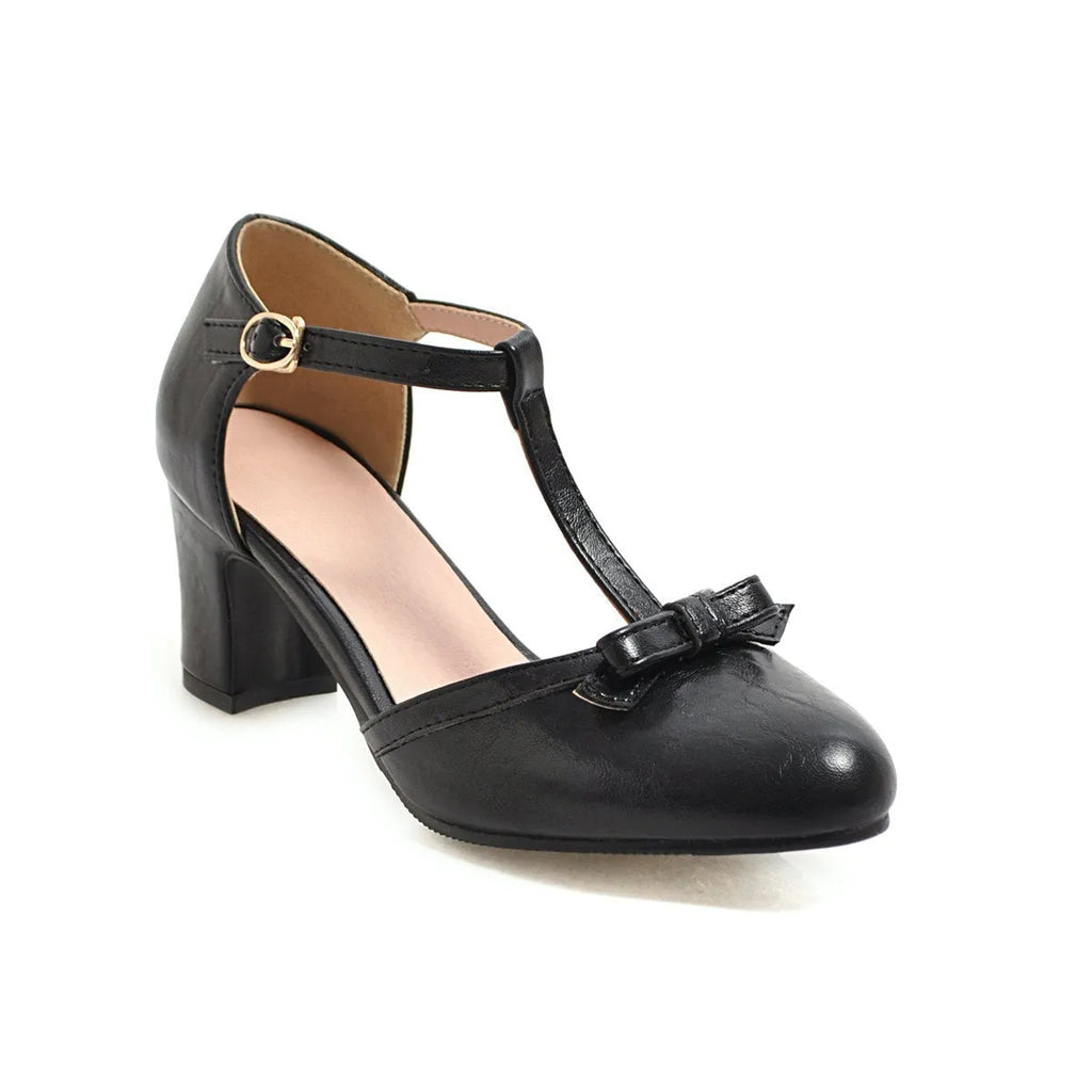 Women's apricot coloured chunky heel sandals with a bow decoration and buckle strap.