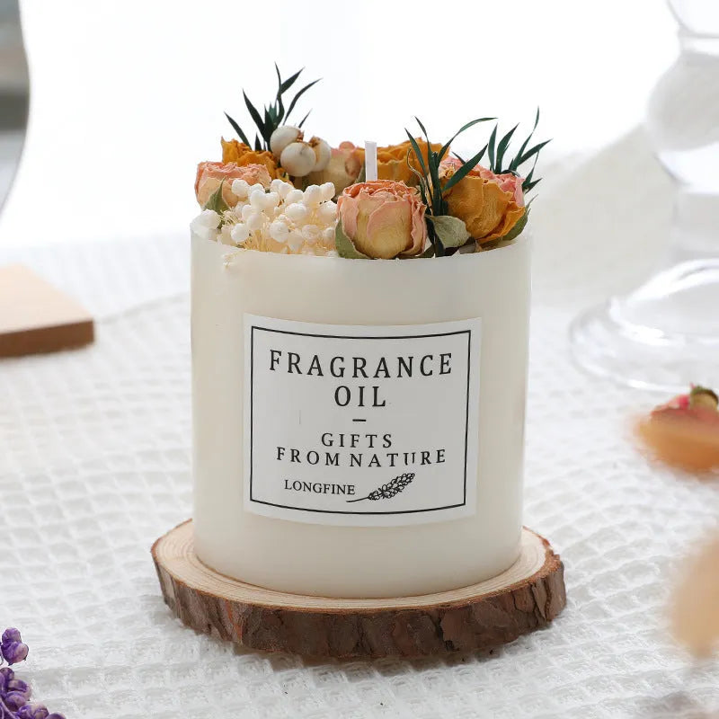 Decorative dried flower aromatherapy candle on a wooden chip base, shown with a gift box.