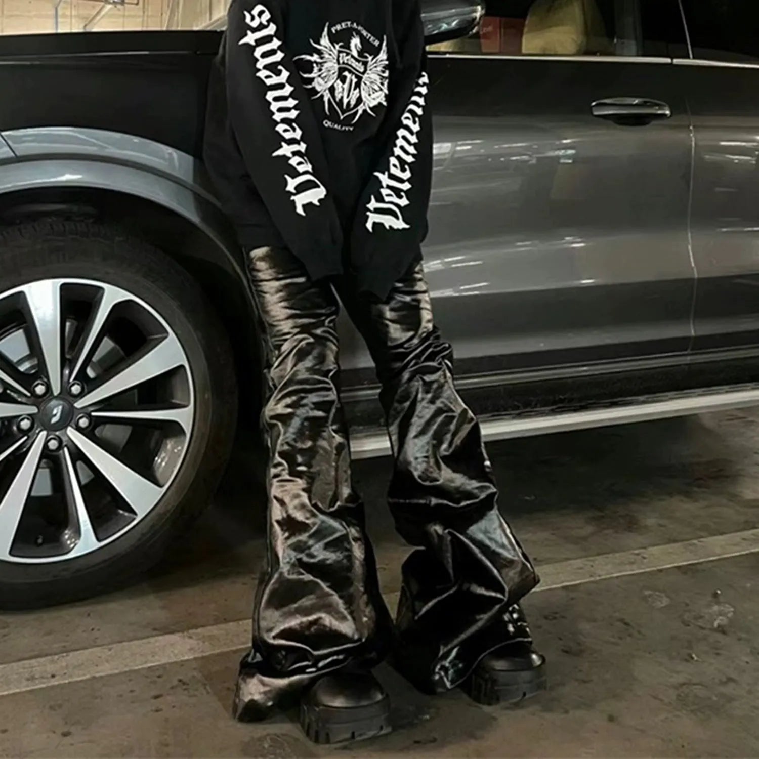 Black coated skinny jeans with a shiny patent leather finish and straight leg cut.