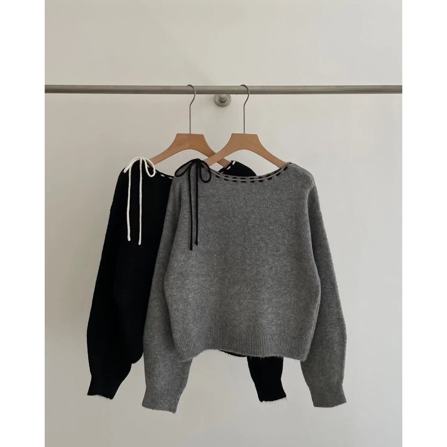 Grey loose-fitting women's knitwear pullover jumper on a hanger.