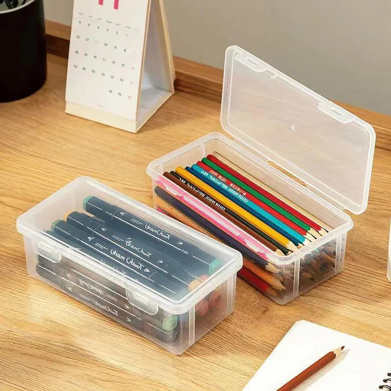 Transparent plastic stationery storage box containing pencils and drawing supplies