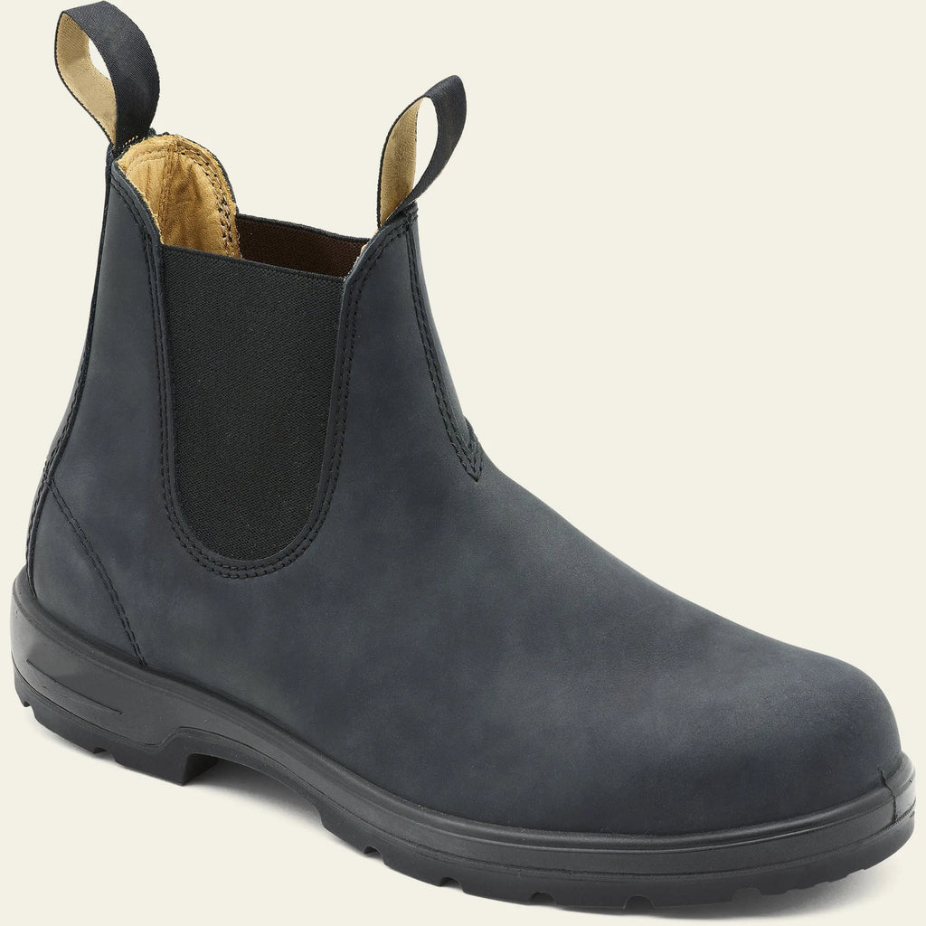 Vintage brown Chelsea boots with frosted finish and car suture detailing on a wooden floor.