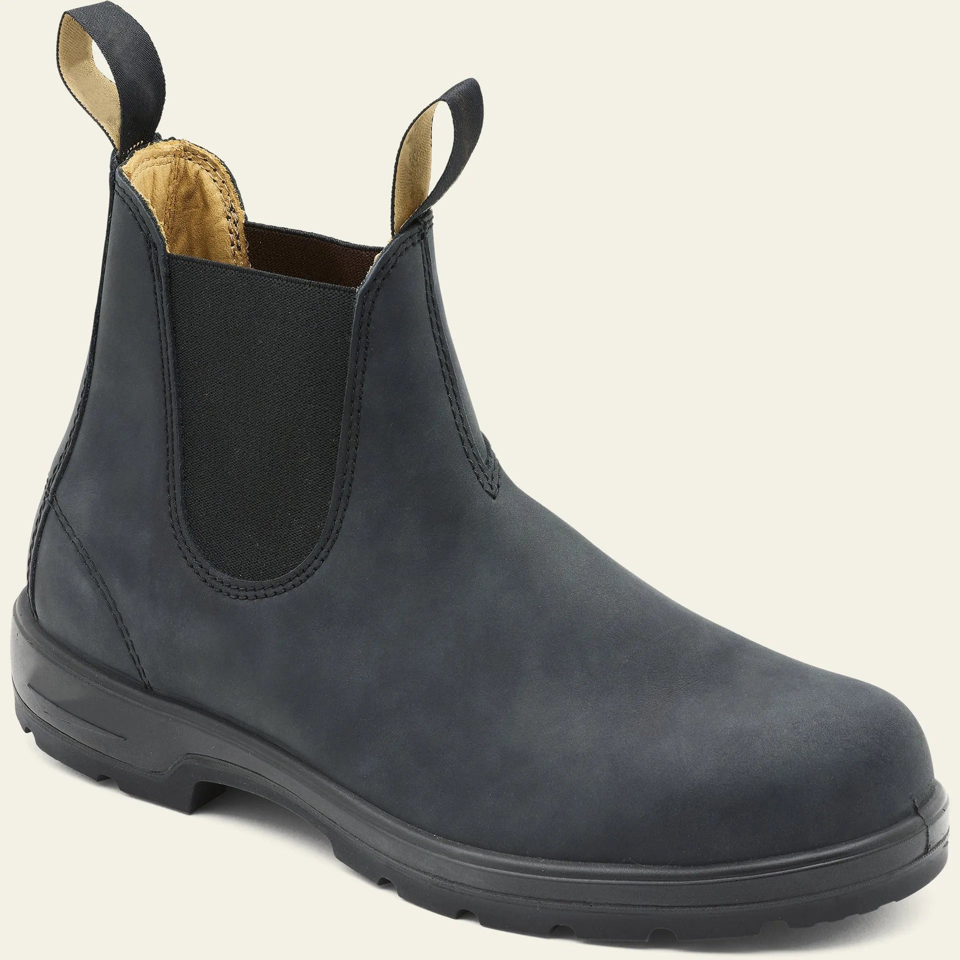 Vintage brown Chelsea boots with frosted finish and car suture detailing on a wooden floor.