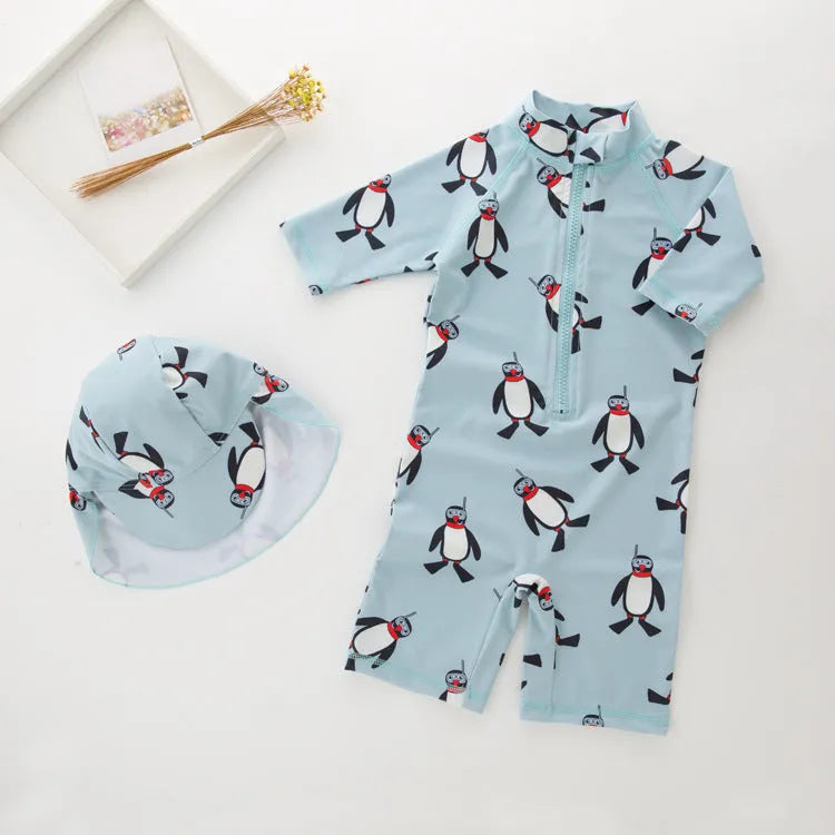 Boy's blue penguin print long sleeve swimsuit top and shorts with matching swimming cap.