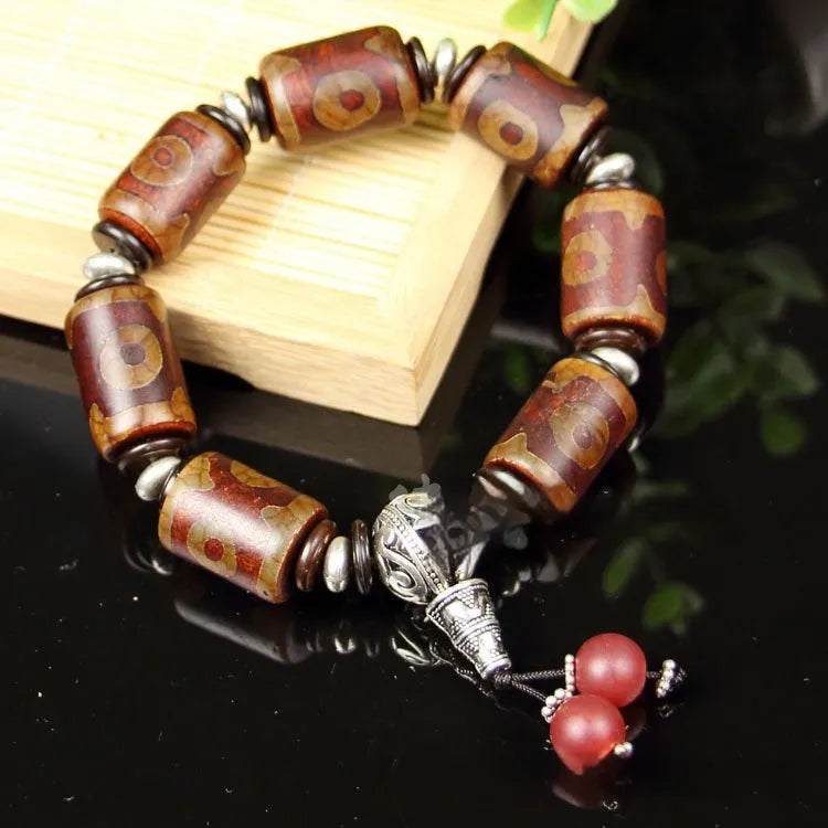 Distressed agate Tibet bead bracelet with three-eye motifs and multiple traditional bead styles on wrist