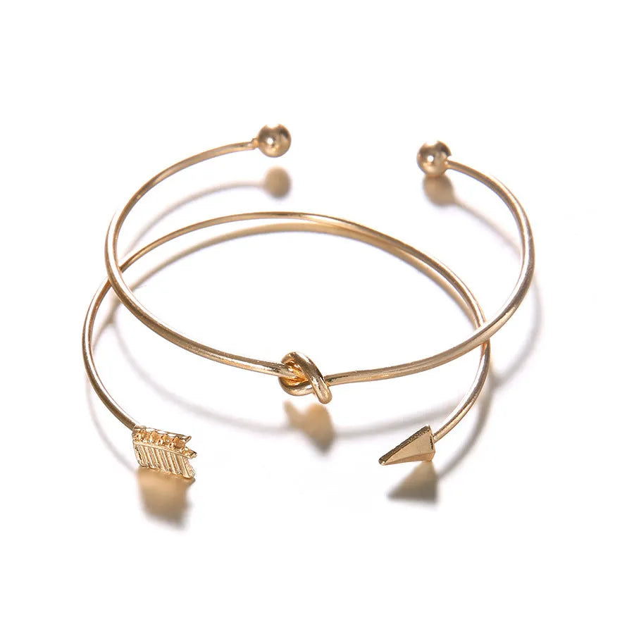 Women's vintage cuff bracelet with arrow and knotted design in gold electroplated alloy