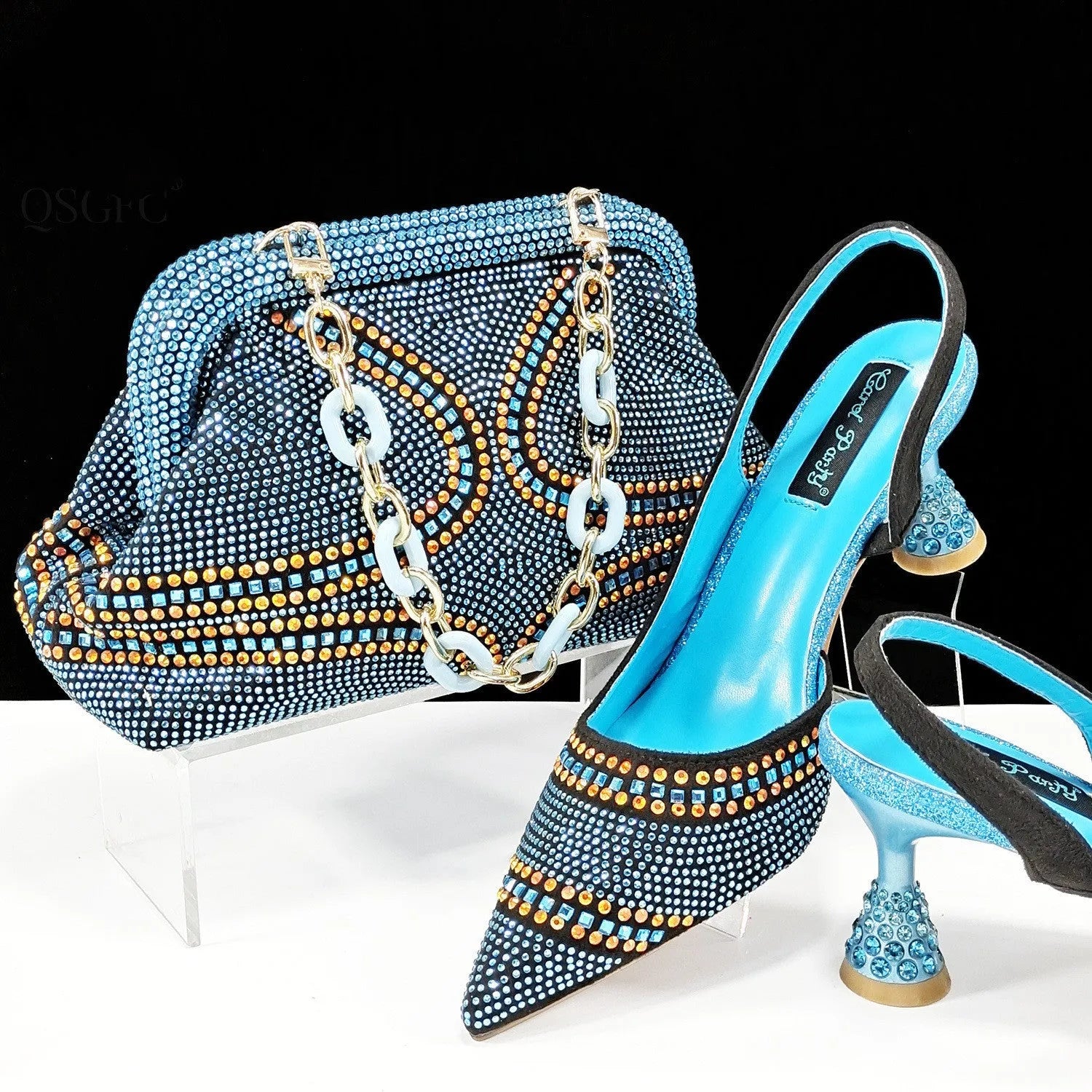 Women's pointed toe high heel shoe with rhinestones and matching small bag in blue.