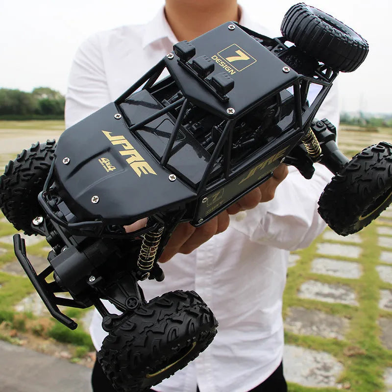 Large black 4WD remote control climbing car on rough terrain with wireless controller