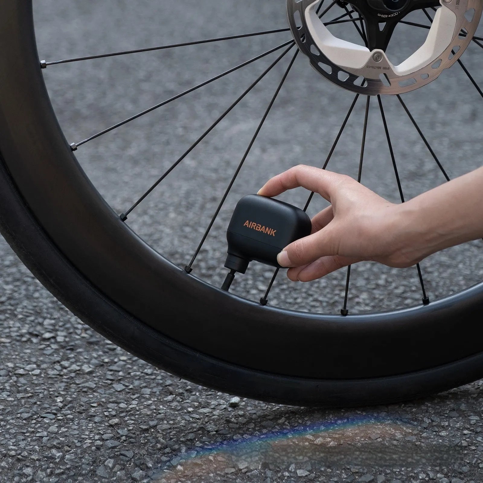 Black AS100 mini electric bicycle pump with USB cable and waterproof storage bag.