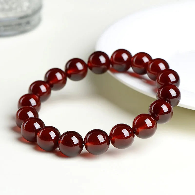 Natural orange red garnet crystal ball bracelet with a traditional metal Ruyi-style clasp.