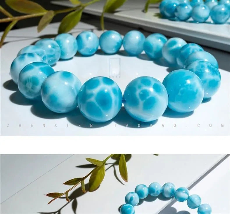 Blue Maillard-style bracelet with bodhi beads, natural crystal stone, and pearl accents on a wrist.
