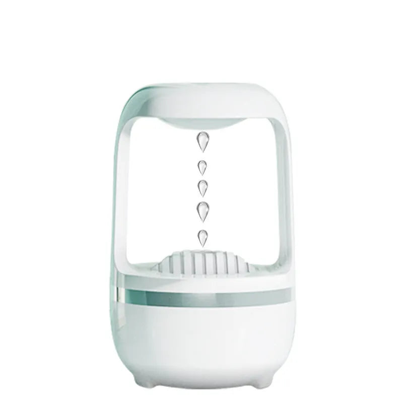 White anti-gravity humidifier with floating water droplet on a desk next to a USB cable